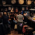 Dive Bar people sitting on bar chairs while drinking and talking