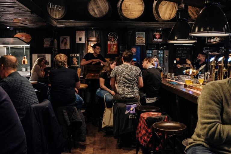 Dive Bar people sitting on bar chairs while drinking and talking