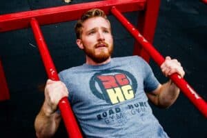 Soft challenge, man in gray crew neck t-shirt holding red metal bar